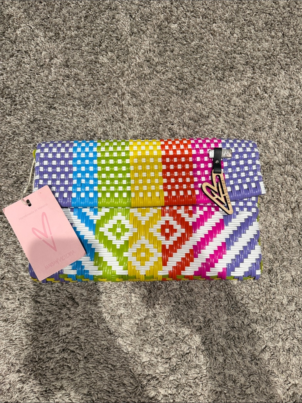 Multicolor recycled plastic woven clutch.